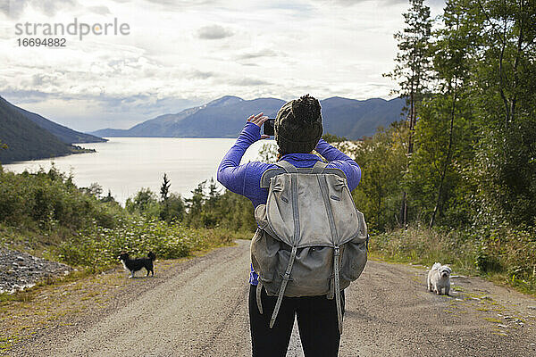 Ein junger Rucksacktourist beim Fotografieren der Fjorde in Norwegen
