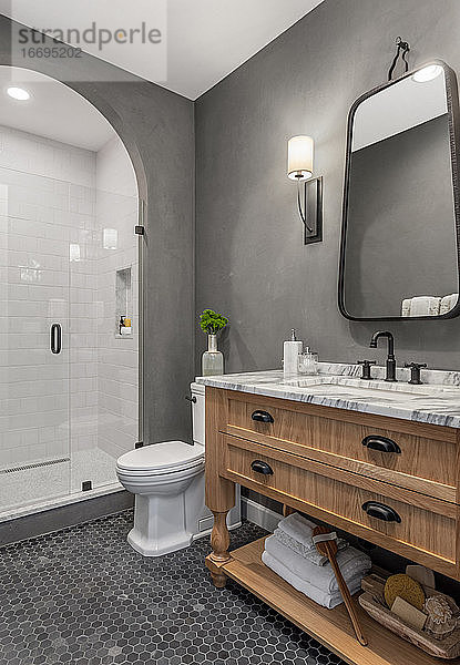 Badezimmer im Haus mit Dusche  Waschtisch  Spiegel  Waschbecken und Fliesenboden