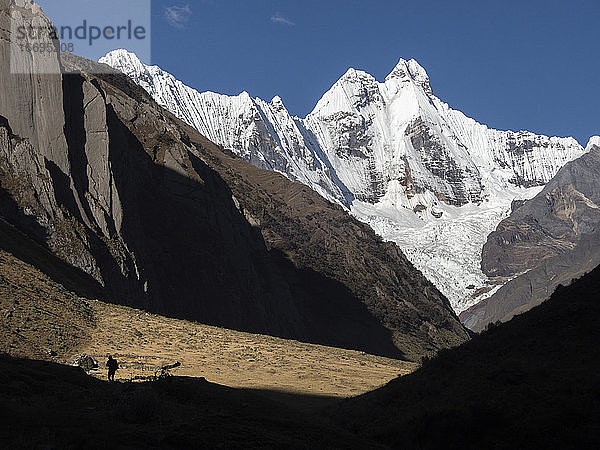 Silhouette einer Person beim Wandern mit Jirishanca im Huayhuash Circuit