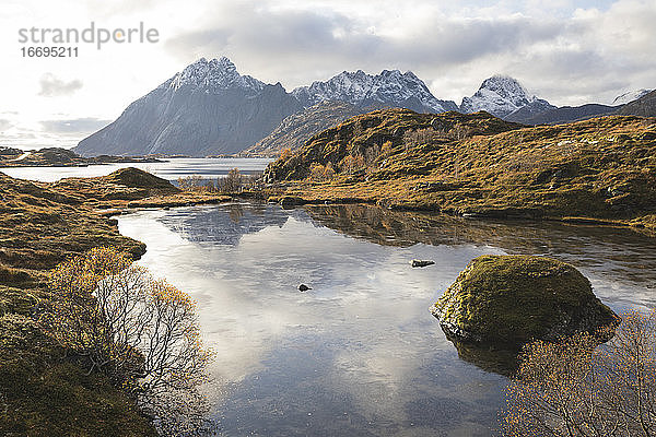 Ruhiger See im Herbst auf den Lofoten mit schneebedeckten Bergen