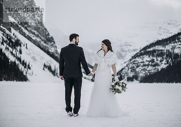 Braut und Bräutigam Hochzeit auf Eis im Winter Lake Louise  Alberta  Kanada