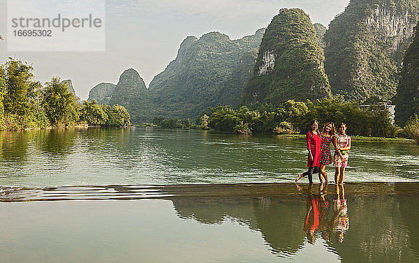 drei schöne Frauen stehen im Fluss Li in der Nähe von Yangshuo