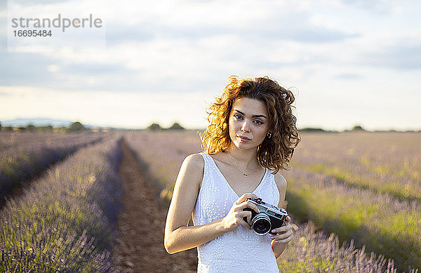 Frau mit Fotoapparat in einem Lavendelfeld