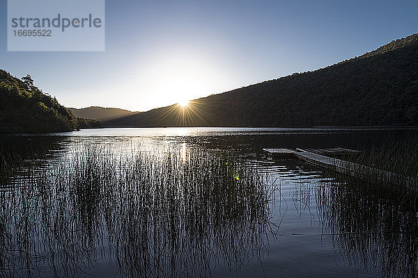 Sonnenuntergang über einem stillen See in der chilenischen Seenplatte