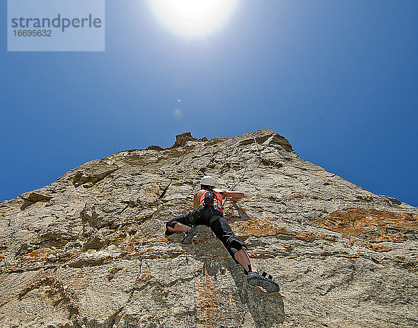 Frau klettert auf Kalksteinfelsen in Swanage / UK