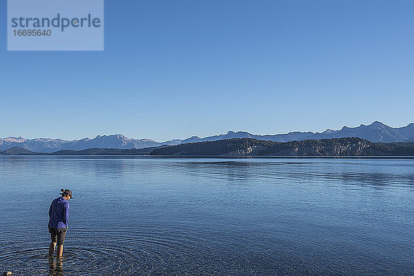Frau probiert das Wasser am Nahuel Huapi See in Patagonien aus