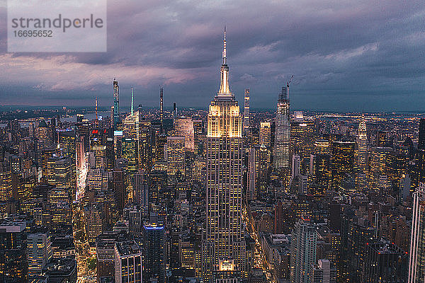 Circa September 2019: Atemberaubender Blick auf das Empire State Building bei Nacht in Manhattan  New York City  umgeben von Wolkenkratzern bei Nacht