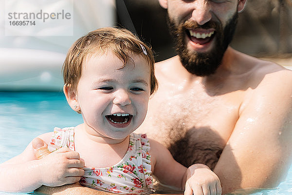 Selektiver Fokus auf das Gesicht eines Mädchens  das lachend im Wasser einen Mann umarmt