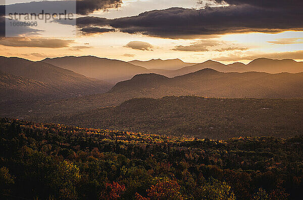 Ein dramatischer Sonnenuntergang wirft Licht über das Laub im nördlichen New Hampshire