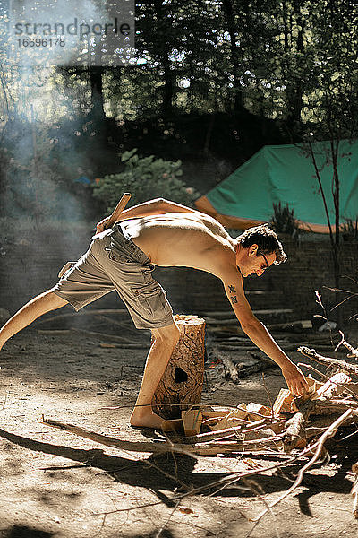 Oben-ohne-Mann spaltet Brennholz