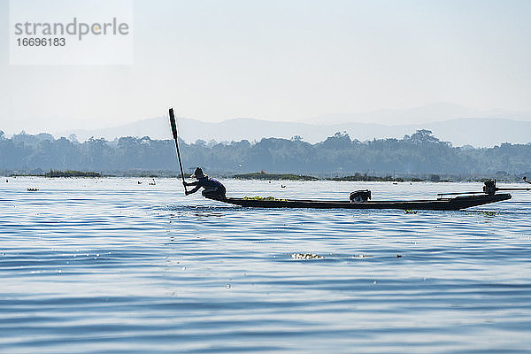 Fischer fängt mit einem Paddel Fische vom Boot aus  Inle-See  Nyaungshwe  Myanmar