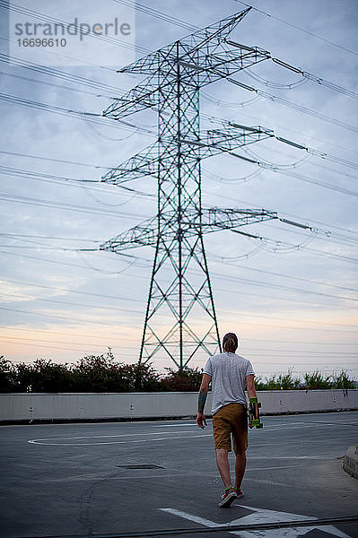 Ein Junge fährt mit dem Skateboard in der Hand