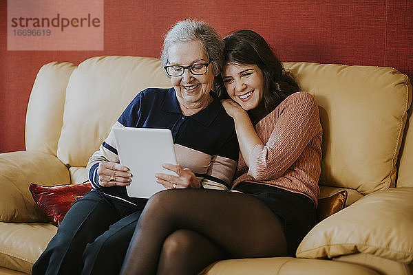 Enkelin und Großmutter schauen etwas auf dem Tablet