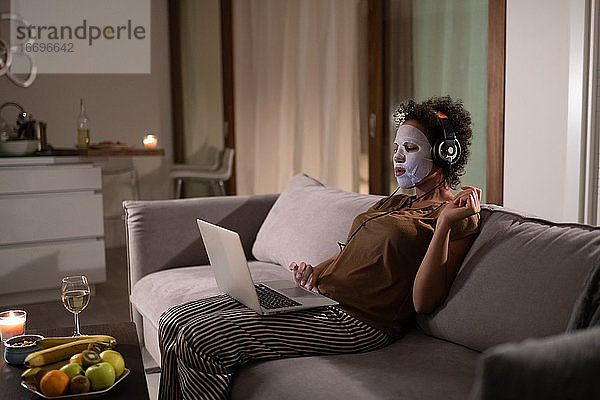 Afroamerikanische Frau mit Folienmaske und Laptop