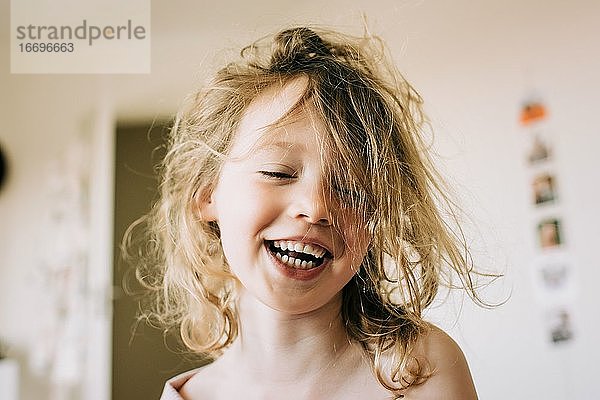 Porträt eines lachenden jungen Mädchens nach dem Aufwachen am Morgen