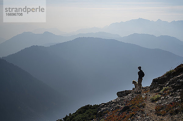 Wildfire Smoke Berg Schichten mit Silhouette Wanderer und Hund