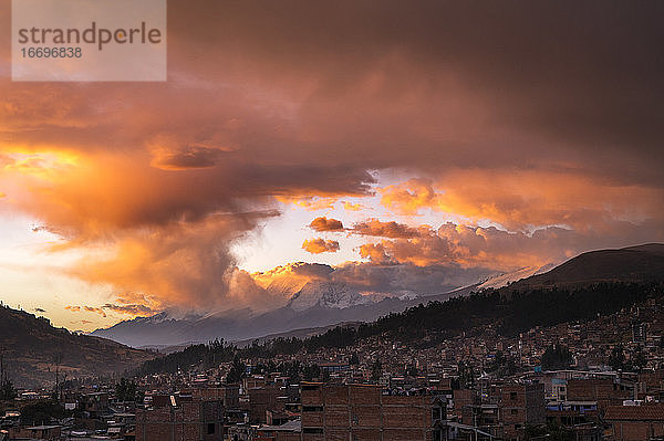 Große orangefarbene Wolken bei Sonnenuntergang über Huaraz und der Cordillera Blanca