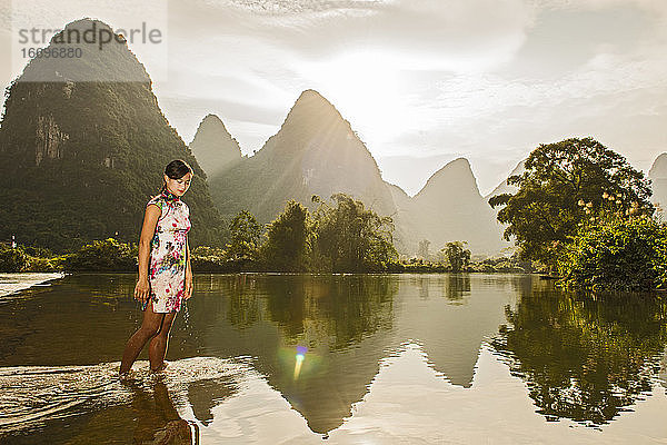 schöne Frau beim Spaziergang durch den Fluss Li in Yangshuo