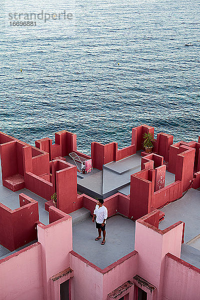 Junger lateinamerikanischer Mann meditativ in 'Muralla Roja' aus Calpe  Spanien