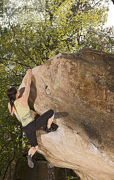 Reife Frau beim Bouldern im Wald von Fontainebleau in der Nähe von Paris