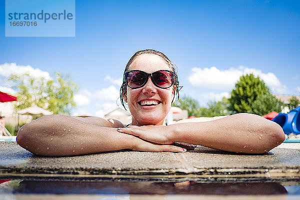 lächelnde Frau in einem Pool an einem heißen Sommertag