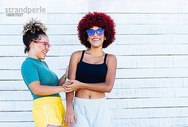 Zwei attraktive Latino-Mädchen mit Afro-Haar in einer sorglosen Haltung.