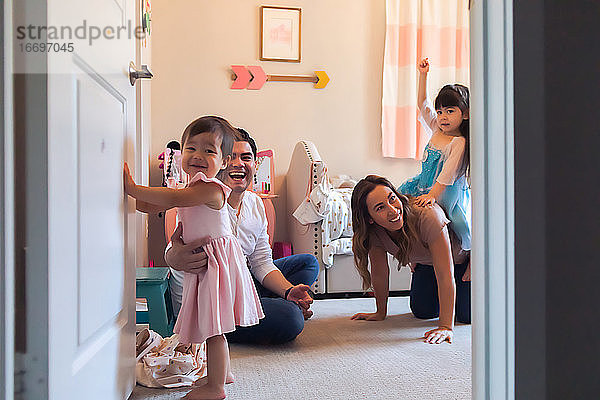 Ein Blick in ein Schlafzimmer  während eine vierköpfige Familie zusammen spielt.