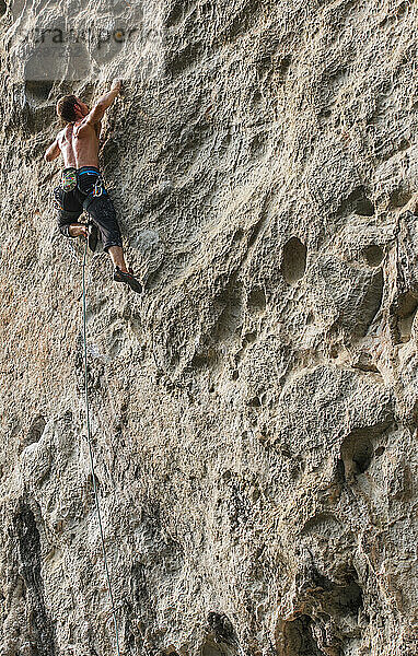 Mann beim Klettern auf dem Kalksteinfelsen Weißer Berg in Yangshuo