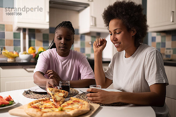 Gemischtrassige Frauen essen gemeinsam Pizza