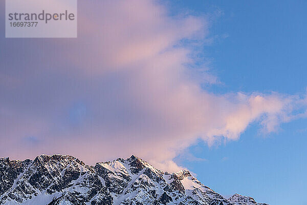 An einem Frühlingstag in den Coast Mountains von British Columbia geht die Sonne über dem Mount Currie unter  der noch mit Schnee bedeckt ist.