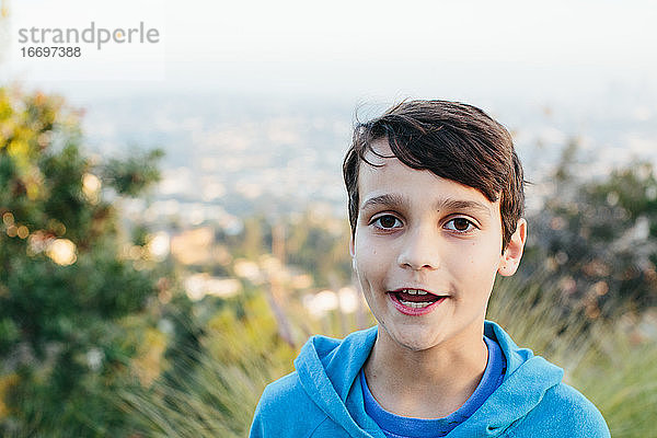 Porträt eines zehnjährigen Jungen an einem Aussichtspunkt  während er spricht