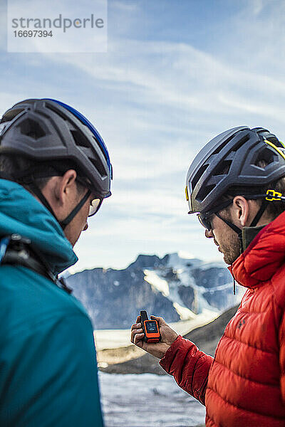 Zwei Forscher benutzen ein GPS  um sich im Gebirge zurechtzufinden.