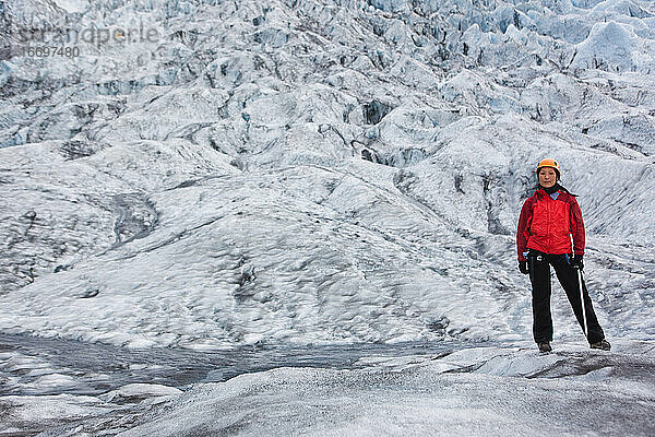 Frau beim Wandern auf dem Gletscher Sólheimajökull im Süden Islands