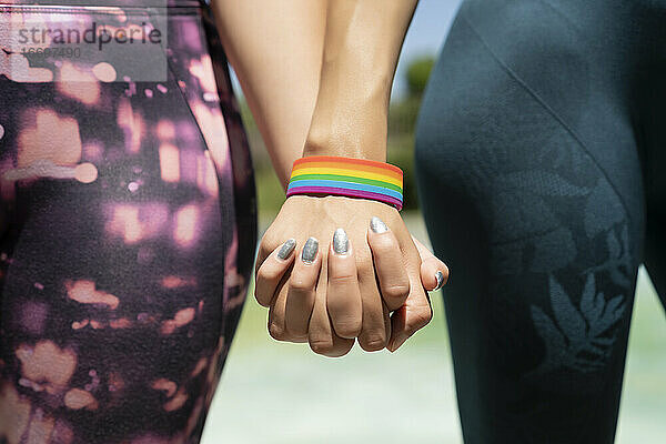 vereinte hände einer frau mit lgtbi armband