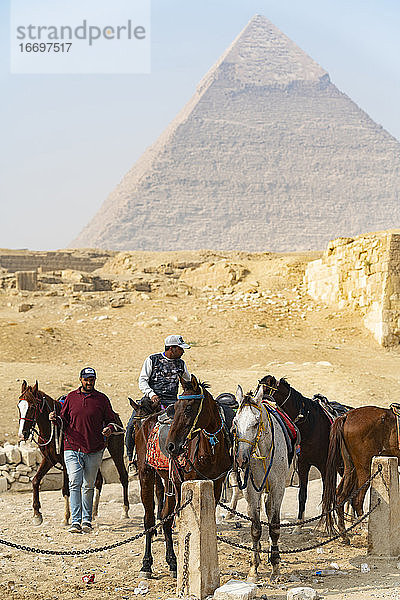 Eine Gruppe von Männern und Pferden vor der Pyramide von Gizeh