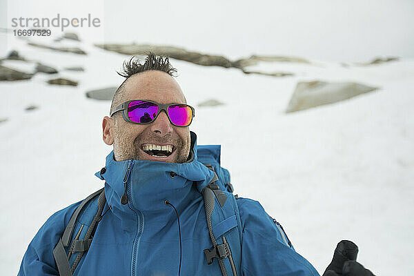 Der Bergsteiger Adam Palmer lacht im Freien.