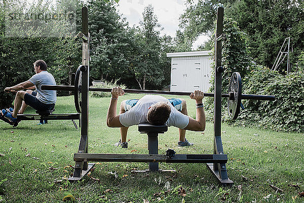 zwei Männer trainieren im Garten in ihrem Fitnessstudio