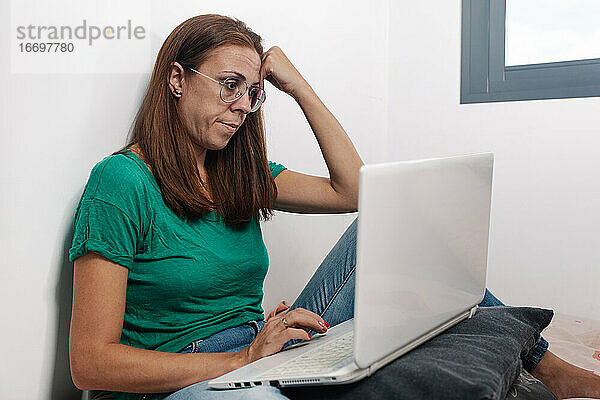 Konzentrierte Frau arbeitet online am Laptop