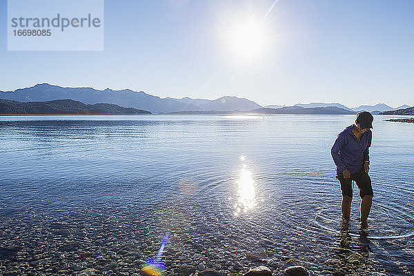 Frau probiert das Wasser am Nahuel Huapi See in Patagonien aus
