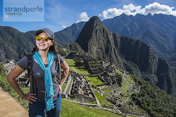 Frau in den Inka-Ruinen schaut lächelnd in die Kamera  Machu Picchu  Peru