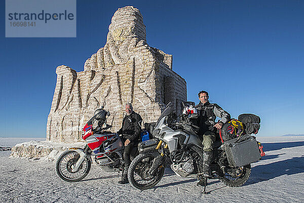 zwei Männer und ihre Reisemotorräder in den Salinen von Uyuni