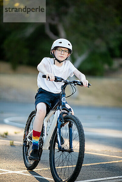 Tween fährt an einem Sommertag in kurzen Hosen Mountainbike im Freien