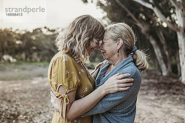 Lifestyle-Porträt einer erwachsenen Mutter und einer älteren Mutter  die sich umarmen