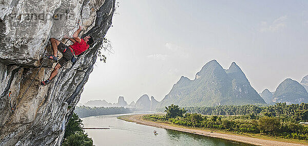 Mann beim Klettern am River Side in Yangshuo  einem Kletter-Mekka in China