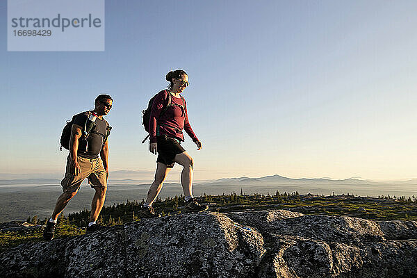 Ein gemischtrassiges Paar erreicht den Gipfel eines Berges  Appalachian Trail Maine