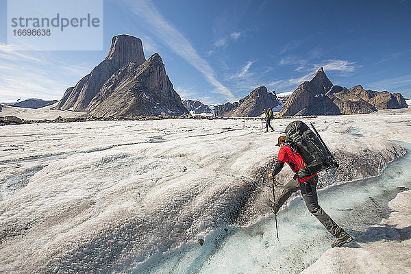 Ein Bergsteiger überquert einen Fluss auf dem Caribou-Gletscher  Baffin Island