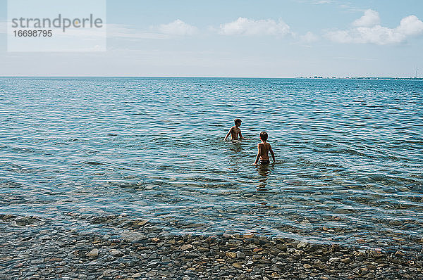 Zwei Jungen waten an einem Sommertag im Ontariosee.