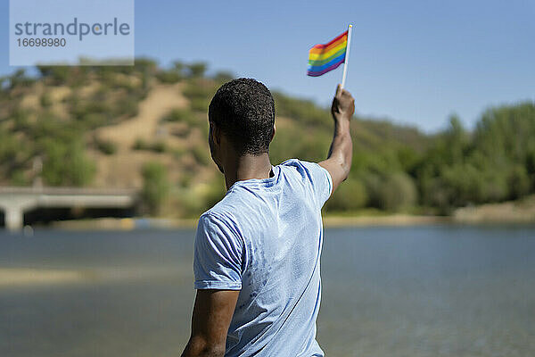 junger Mann mit seiner Gay Pride Flagge