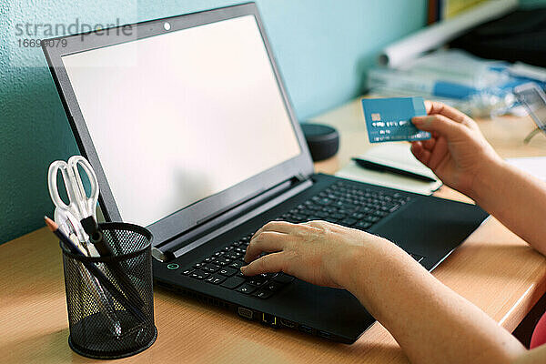 Unbekannte Frau kauft mit Kreditkarte auf ihrem Laptop zu Hause ein