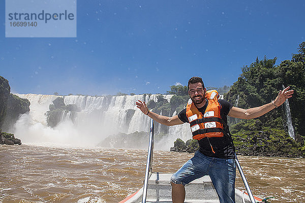 junger Mann posiert vor den Iguacu-Wasserfällen in Argentinien